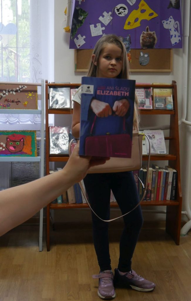 Stojąca dziewczynka z książką w dłoniach